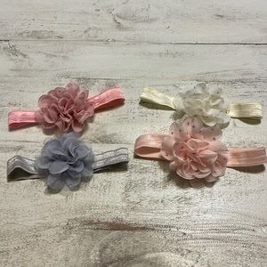 Lot of four baby girl headbands with sparkly flowers, cream, gray and two pinks.